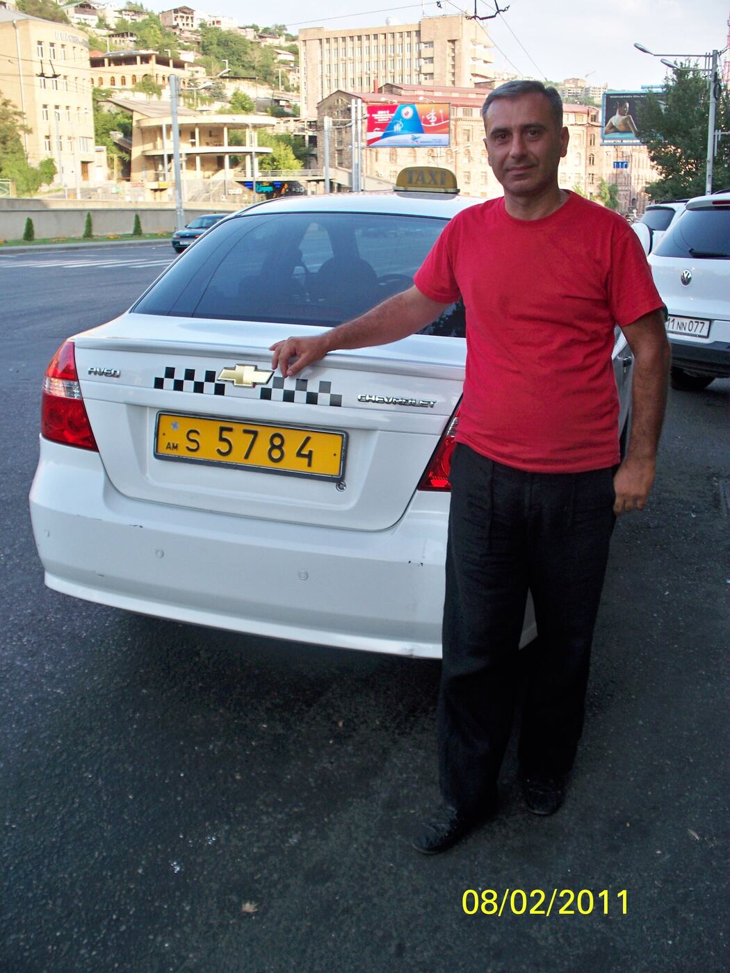 A taxi driver standing beside his car in Yerevan