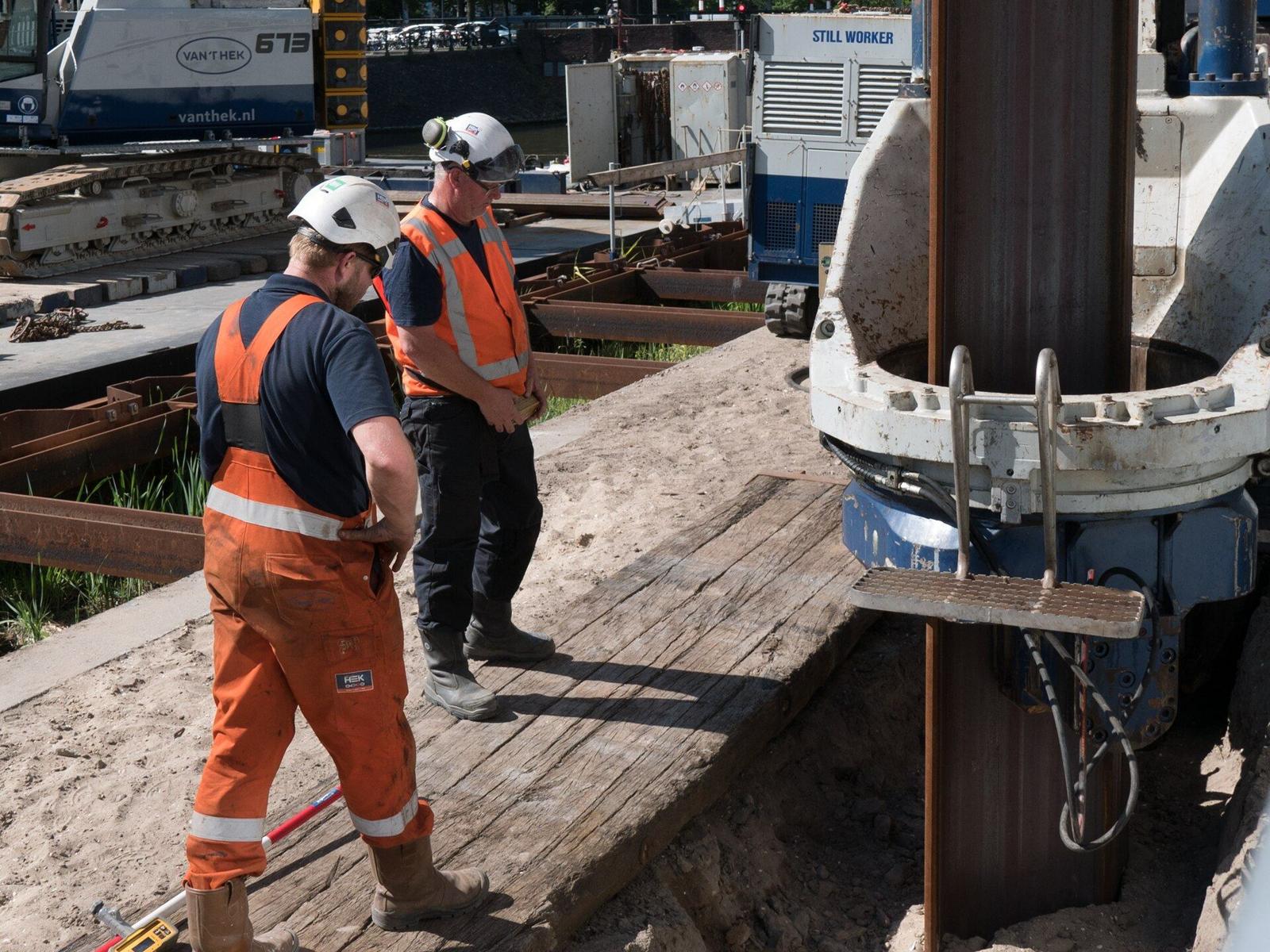Construction workers in safety gear checking work on a building site